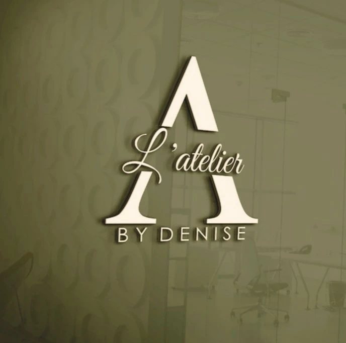 Placă logo L'Atelier by Denise pe peretele salonului